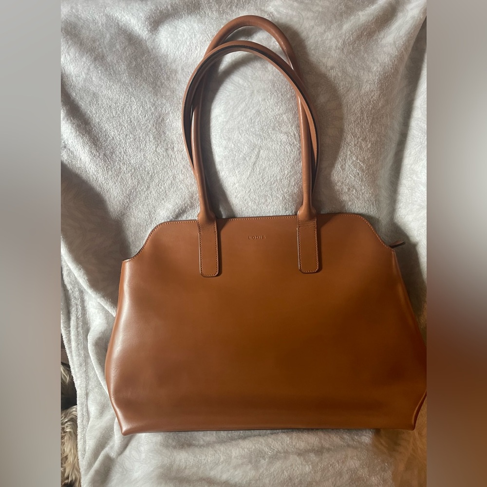 Lodis tan leather tote has top zip closure. Deep, roomy pockets. Magnetic snaps.